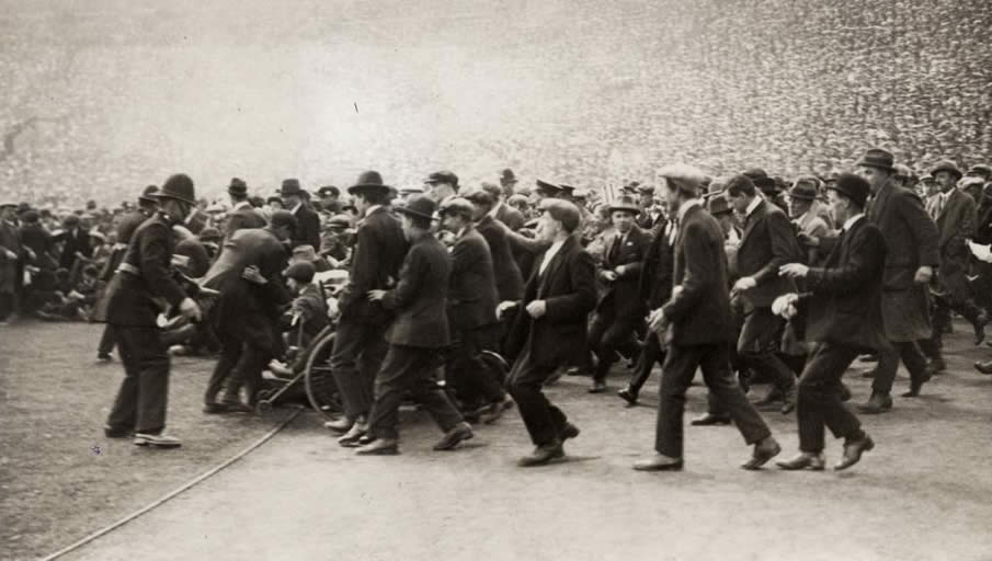 Supporter "riots", the public floods the field, just before the game starts. 300.000 tickets have been sold for the 125.000 seats in the new Wembley stadium. England, London, 1923.