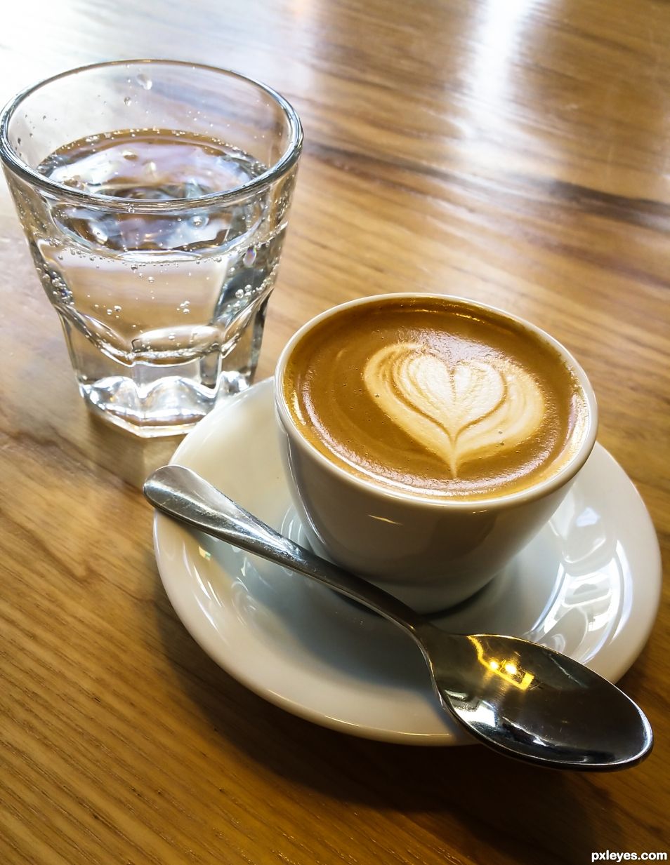 A traditional macchiato served with sparkling water