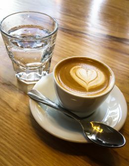 A traditional macchiato served with sparkling water