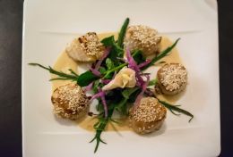 Pan-fried scallops topped with sesame seeds