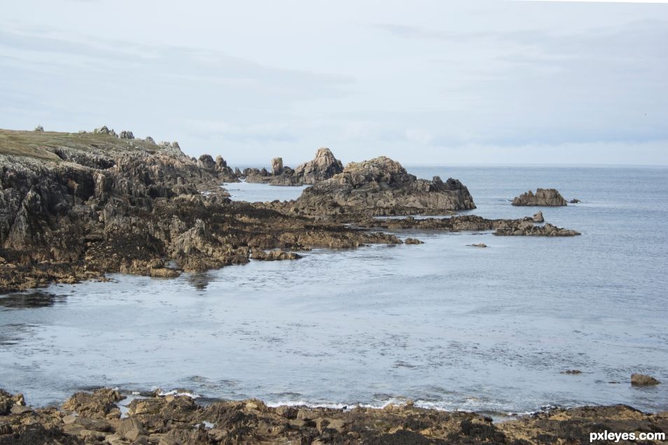 Fierce shore embracing steel blue sea